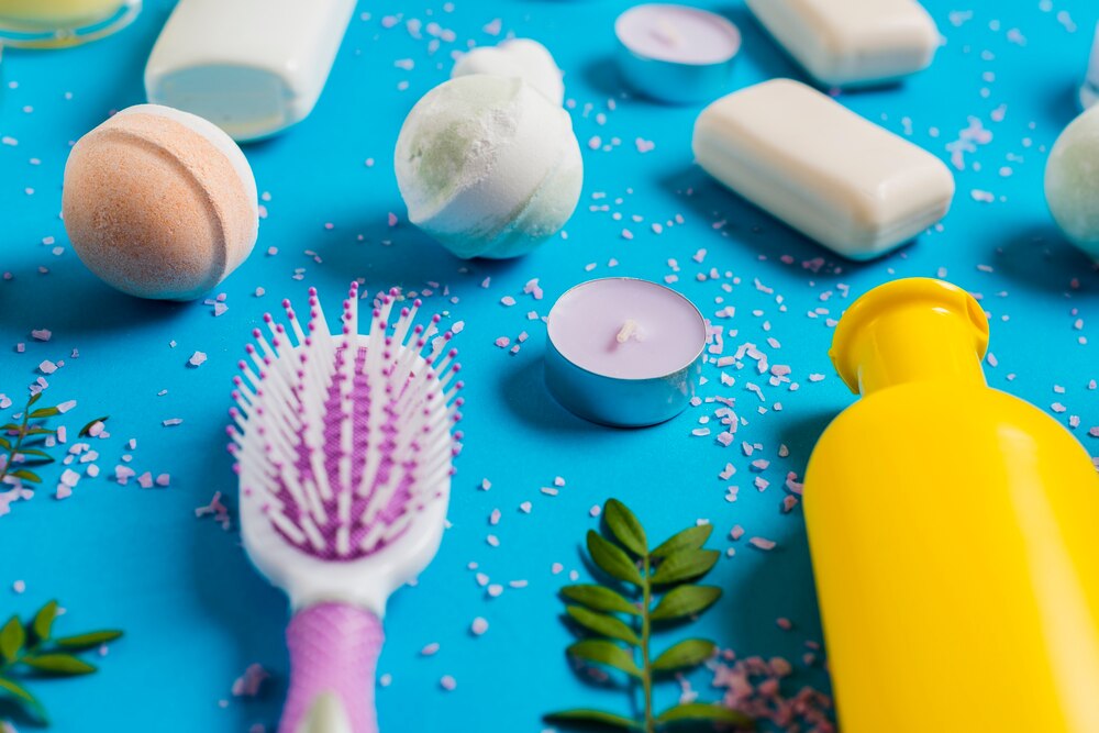 Bath soap with hairbrush and candle on blue background